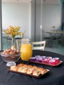 a table with two plates of pastries and a jar of orange juice at Gran Lord Hotel in Pará de Minas