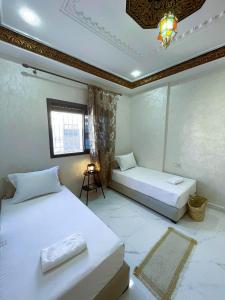 a bedroom with two beds and a window at شقه معاصره ب لمسة مغربيه في فاس in Fez