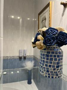 a vase with a bouquet of roses in a bathroom at La Madriguera de Toledo in Bargas