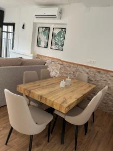 - une salle à manger avec une table et des chaises en bois dans l'établissement Casa Rural Abuelo Raimundo, à Ossa de Montiel