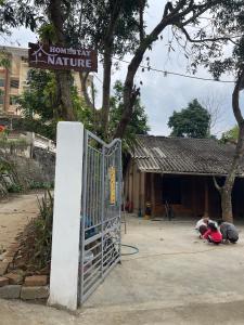 a gate in front of a building with a sign at Homestay Nature in Na Hang