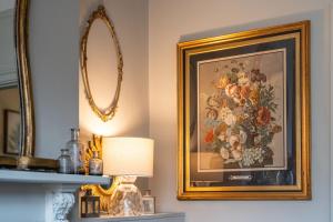 a painting of flowers on a wall next to a lamp at Victorian Townhouse 5 bedrooms Cheltenham in Cheltenham