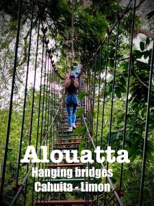 una mujer caminando a través de un puente colgante en la jungla en Alouatta Hanging Bridges Adventure and Lodge en Cahuita