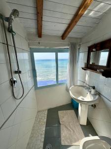 uma casa de banho com um chuveiro, um lavatório e uma janela em Golden Home em Anzio