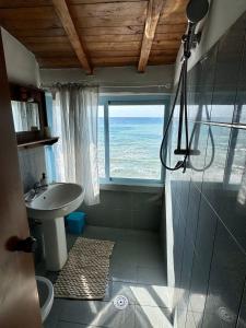 uma casa de banho com um chuveiro, um lavatório e uma janela em Golden Home em Anzio