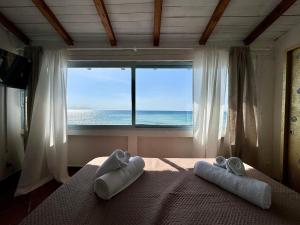 a bedroom with a view of the ocean from a window at Golden Home in Anzio