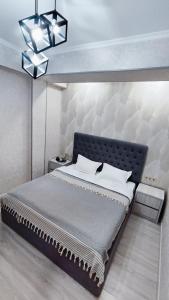 a bedroom with a large bed with a wall at Mountain View Two in Tashkent