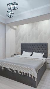 a bedroom with a large bed with a wall at Mountain View Two in Tashkent