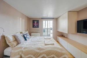 パリにあるAppartement Art Decoのベッドルーム1室(大型ベッド1台、薄型テレビ付)