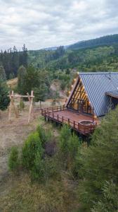 Cabaña Alpina Experience : مبنى خشبي كبير مع مقاعد على تلة