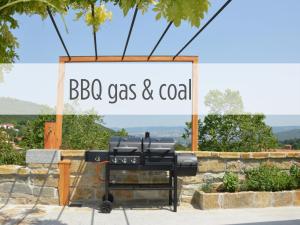 a barbecue grill with a sign that reads bbq gas and coal at Casa Miranda in Zgornje Škofije