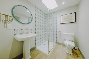 La salle de bains est pourvue de toilettes, d'un lavabo et d'un miroir. dans l'établissement Number 2 Puddies at The Old Dairy Clevedon, à Clevedon
