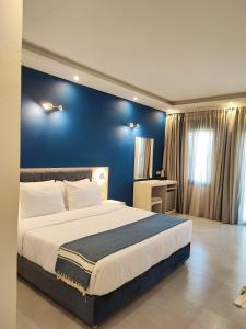 a bedroom with a large bed with a blue wall at Azul Eco Hotel in Skaleta