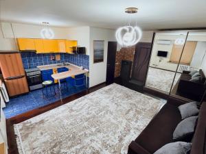 eine Küche und ein Wohnzimmer mit einer Couch und einem Tisch in der Unterkunft Great location Arbat, Zhibek zholy 81 & drinking water in Almaty