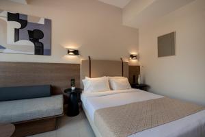 Habitación de hotel con cama y sofá en Dimitra Hotel & Apartments by Omilos Hotels en Kokkíni Khánion