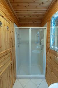 Habitación de madera con baño con ducha. en Large Luxury Log Cabin Getaway en Ballyconnell