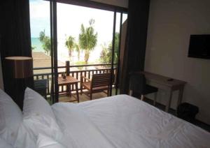 a bedroom with a bed and a view of the ocean at Chidlom Resort in Haad Chao Samran
