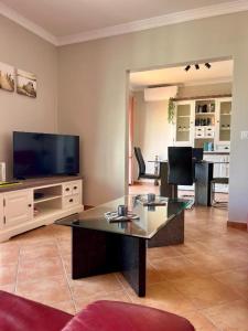a living room with a table and a television at Penthouse Casa Torre in Armação de Pêra