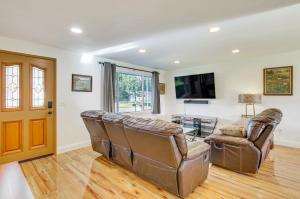een woonkamer met 2 leren stoelen en een televisie bij Charming Arlington Home with Hot Tub and Fenced Yard! in Arlington