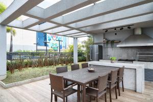 Apartamentos completos em Pinheiros a uma quadra da Faria Lima - HomeLike في ساو باولو: مطبخ مع طاولة وكراسي ومطبخ مع اوروس