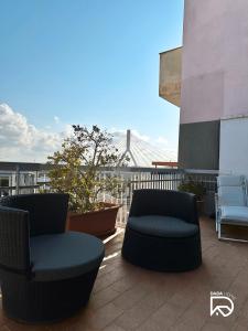 dwa krzesła siedzące na balkonie z widokiem na most w obiekcie DADA Home w mieście Bari