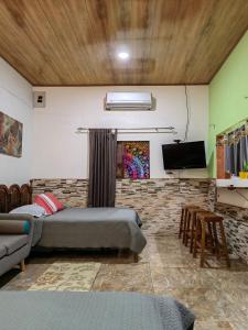 a living room with two beds and a tv at Casa Victoria in Puntarenas