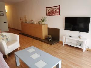 een woonkamer met een tv en een bank en een tafel bij Elsi's place in Premiá de Mar