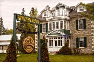 a house with a street sign in front of it at Spruceholme Inn in Fort Coulonge