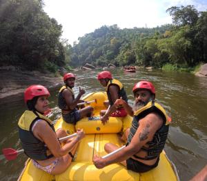 un grupo de personas en una balsa en un río en Tropical river resort, en Bulatkohupitiya