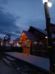 a log cabin with a light on the deck at night at Hostería Rutalsur in Tolhuin