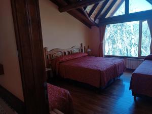 1 dormitorio con 2 camas y ventana grande en Hostería Rutalsur en Tolhuin