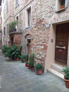 a brick building with potted plants next to a door at La casa di Virma in Castelnuovo Berardenga
