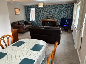 a living room with a table and a couch at 8 Tan Y Coed in Rhosllanerchrugog