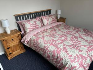 a bedroom with a bed and two night stands at 8 Tan Y Coed in Rhosllanerchrugog