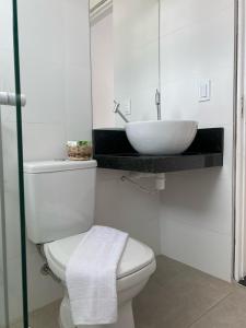 een badkamer met een wit toilet en een wastafel bij Pousada Cantinho da Barra in Barra de São Miguel