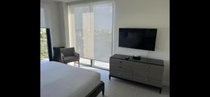 a bedroom with a bed and a tv and a chair at 2 bed 2 bath Luxury Condo in Miami