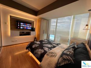 uma sala de estar com um sofá e uma televisão de ecrã plano em Azure Urban Resort Residences em Manilla