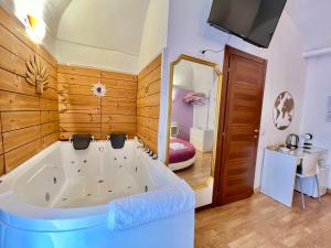 eine große Badewanne in einem Zimmer mit einem Schlafzimmer in der Unterkunft CANTU' SUITE in Catania