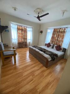 sala de estar con cama y suelo de madera en Hotel Young Mamta, en Srinagar