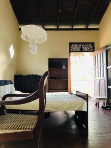ein Schlafzimmer mit einem Bett, einem Stuhl und einem Fenster in der Unterkunft Dheera niwasa villa in Talpe