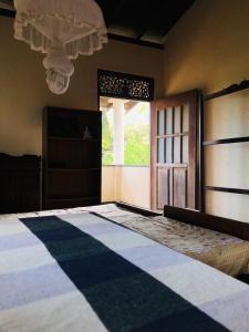 a bedroom with a bed with a window and a door at Dheera niwasa villa in Talpe