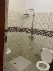 a bathroom with a shower with a toilet and a sink at Appartement chambre 2 in Dakar