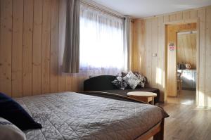 sypialnia z łóżkiem, kanapą i oknem w obiekcie APARTAMENTY "U Bliźniaków" w Zakopanem