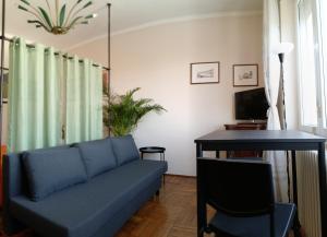 a living room with a blue couch and a desk at MAX and SEA parking in Sanremo