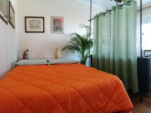 a bedroom with an orange bed with an orange blanket at MAX and SEA parking in Sanremo