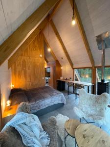 ein Schlafzimmer mit einem Bett und einem Schreibtisch in einem Zimmer in der Unterkunft El Diucón Eco Lodge in Villa Meliquina