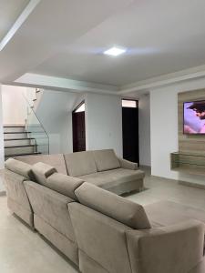 een woonkamer met een bank en een tv bij Pousada Cantinho da Barra in Barra de São Miguel