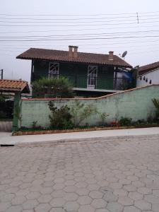 une maison verte avec un toit en carrelage dans une rue dans l'établissement Casa da Joana, à Monte Verde