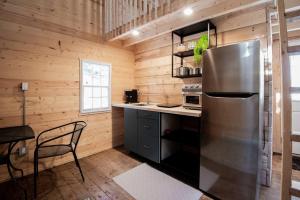 a kitchen with a stainless steel refrigerator and a table at Equuleus Lofted Kabin in Fenelon Falls