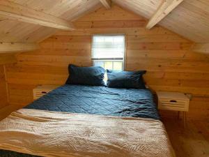 een slaapkamer met een bed in een blokhut bij Equuleus Lofted Kabin in Fenelon Falls
